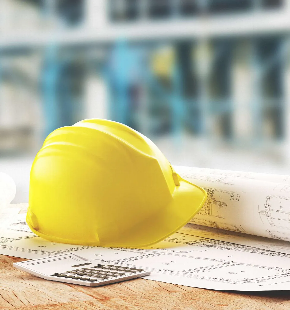 Casque de chantier posé sur des plans de maison