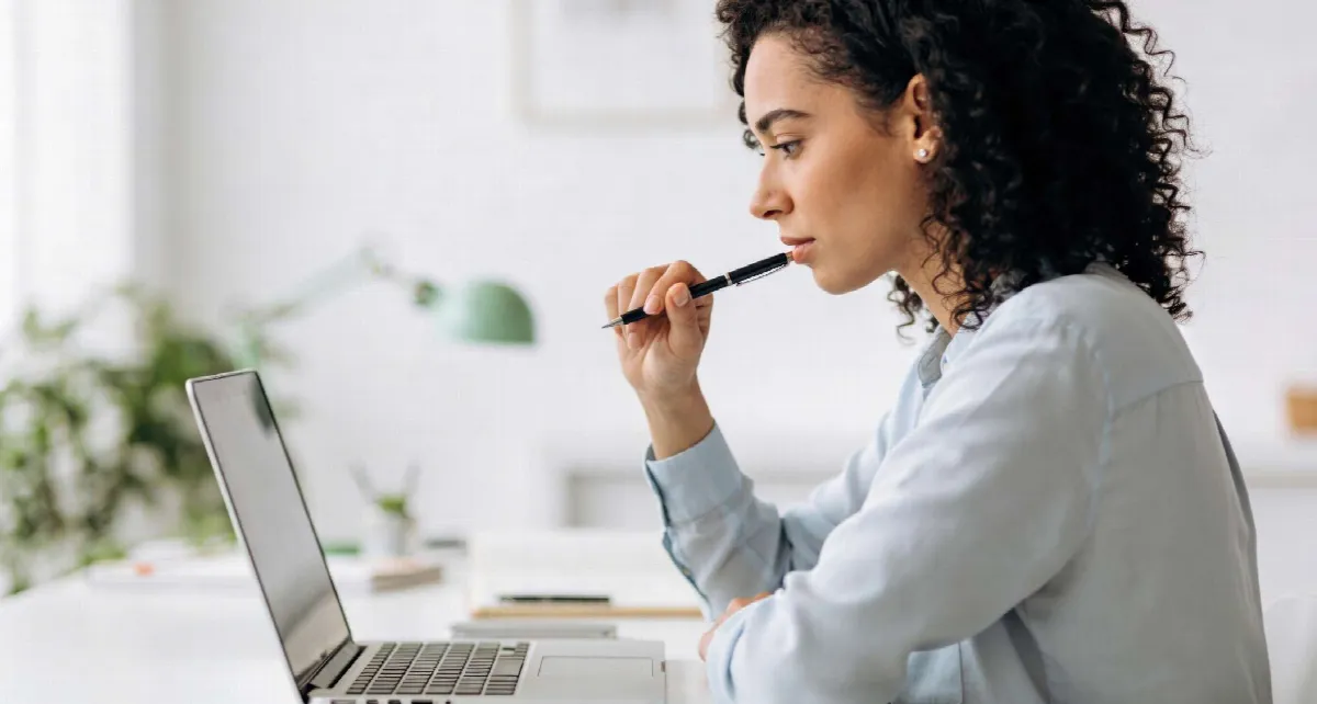 Femme réfléchissant devant son ordinateur